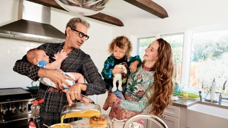 Jeff Goldblum in a black shirt at his kitchen with wife and children.
